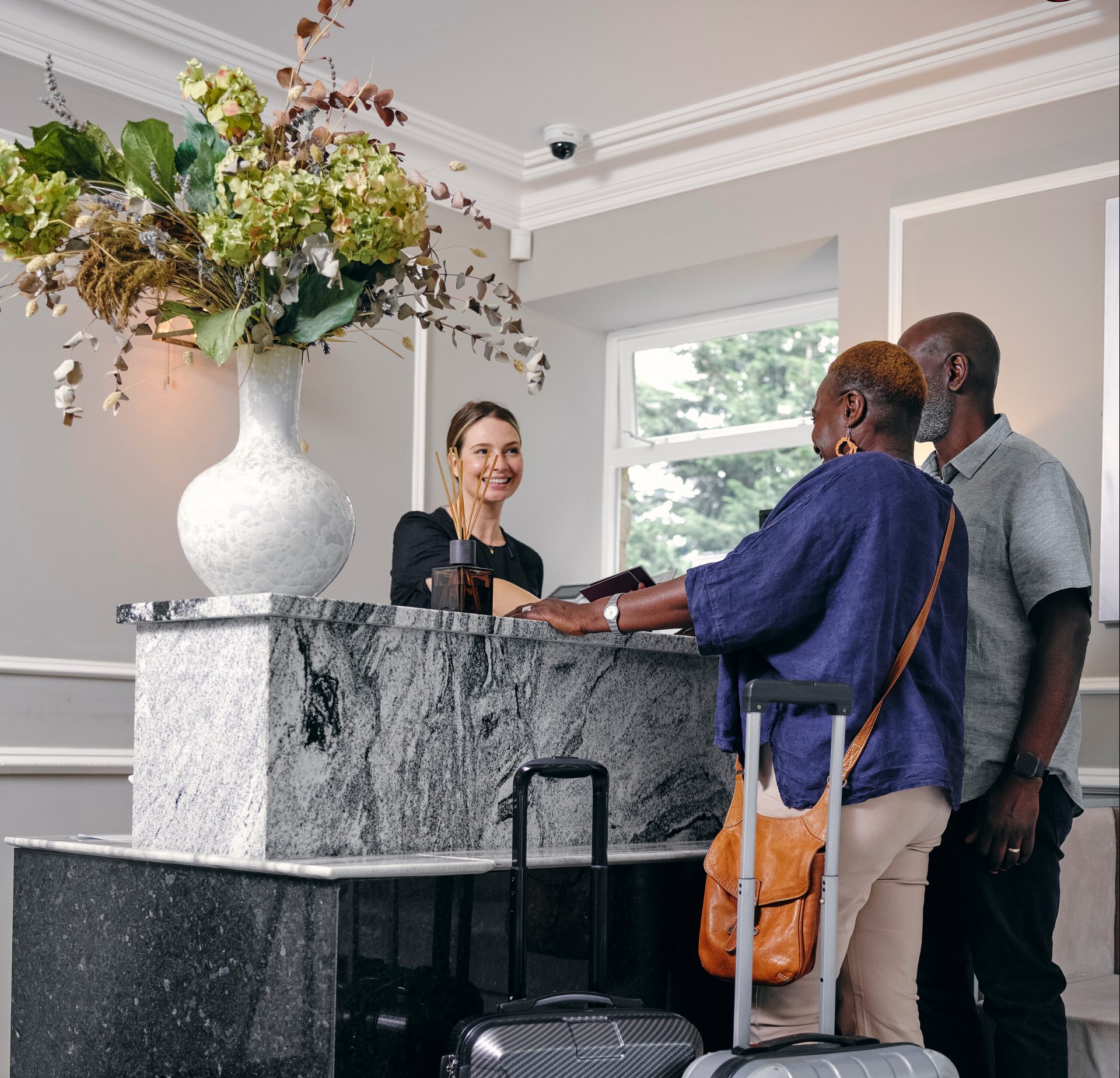 Casal com malas na receção do hotel