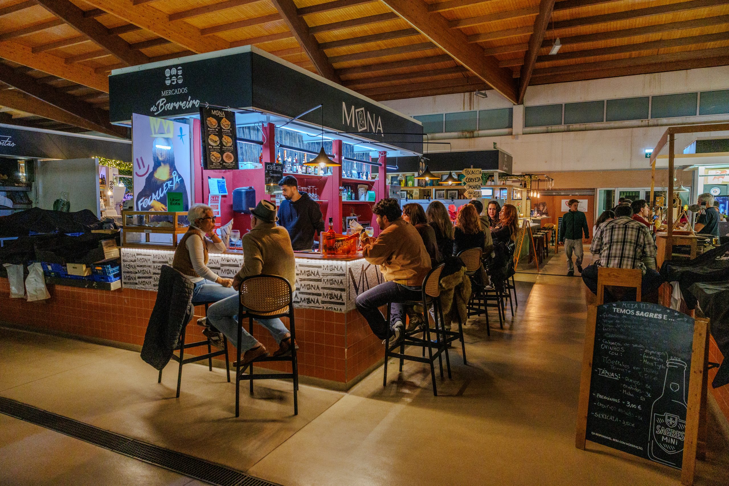 Fotografia de interior do Mercado 1º de Maio cheio de pessoas a comer